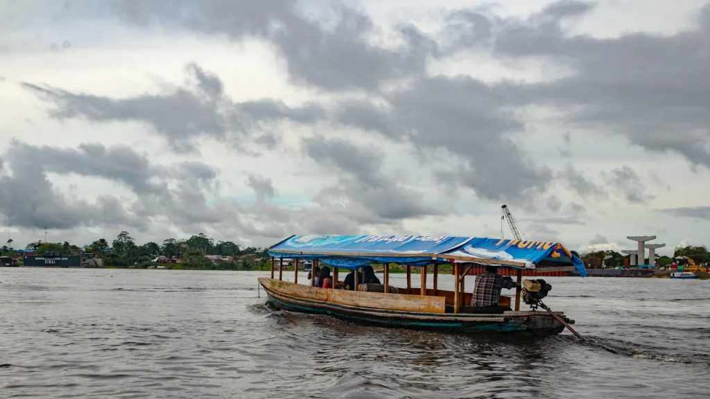 Bateau de transport sur un large fleuve bordé par la forêt amazonienne