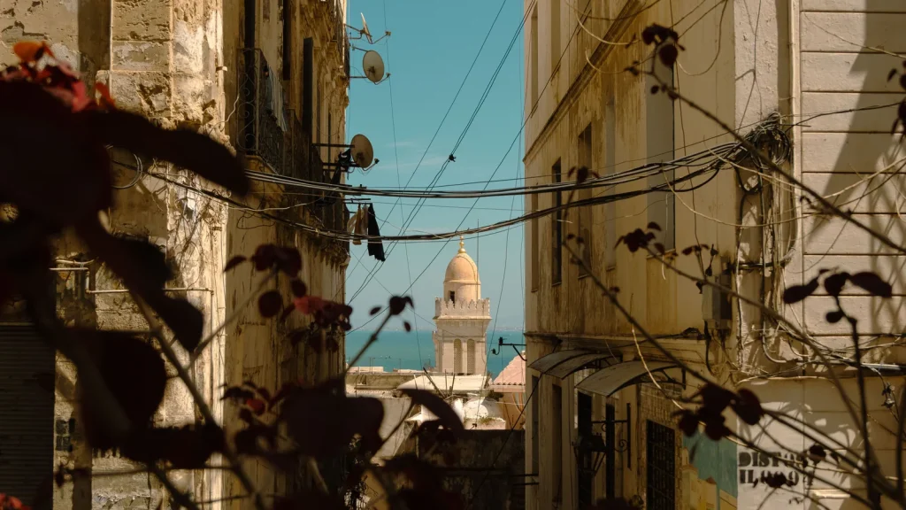 Ruelle de Tunis ouverte sur un minaret et la Méditerranée