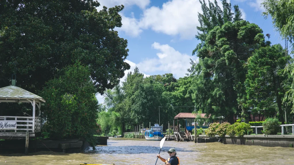 Kayak et bateau sur un bras verdoyant du delta de Tigre